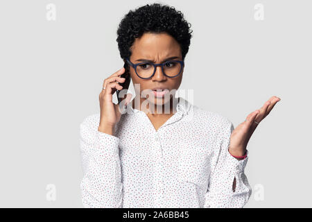 Head shot annoyed African American woman talking on phone Stock Photo