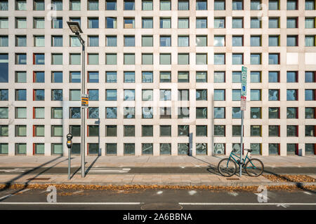 street view with a bike locked by a street nameplate and a street lamp, with modern designed building background Stock Photo