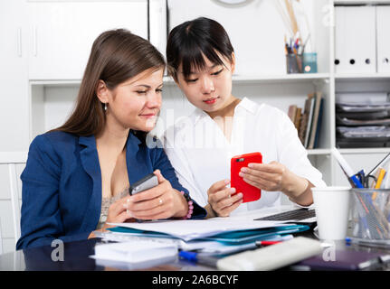 Portrait of positive multiracial team using mobile phones at modern office Stock Photo