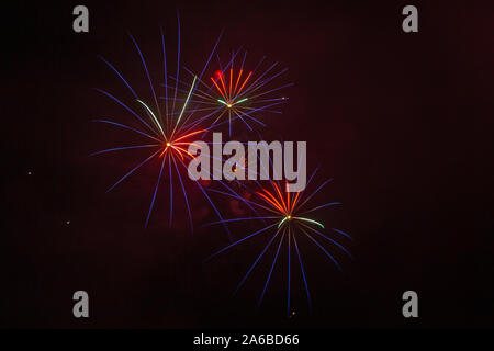 Blue, red and white fireworks against the backdrop of the night sky Stock Photo