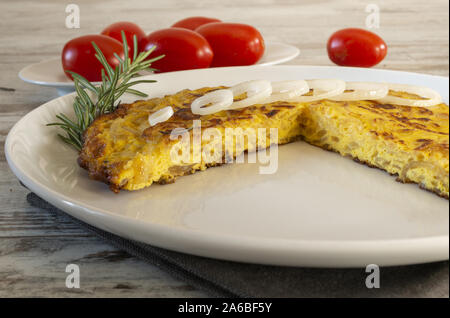 frittata di uova con le cipolle tagliata dal basso e pomodori Stock Photo