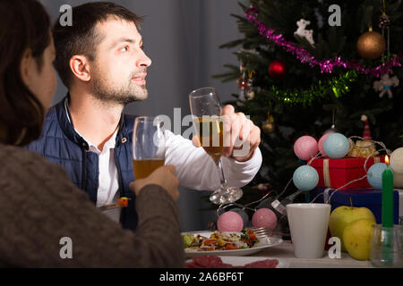 Family couple having christmas dinner with champagne and watching tv Stock Photo