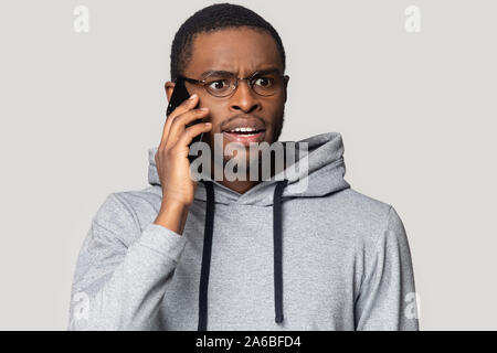 Head shot shocked African American man talking on phone Stock Photo