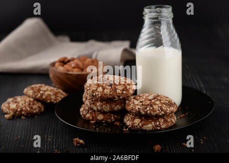 Bottle of milk and homemade whole grain cookies on dark wood background Stock Photo