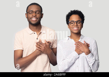Head shot happy African American couple holding hands on chest Stock Photo