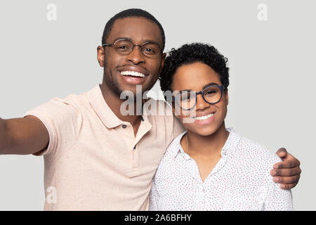 Head shot happy African American couple in glasses taking selfie Stock Photo
