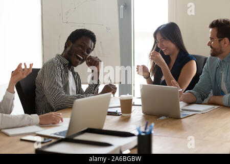 Diverse employees team having fun at meeting in boardroom Stock Photo