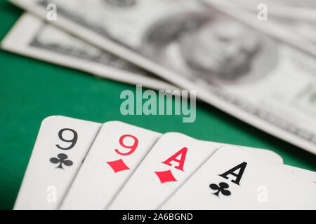 Close up of combination of two pair of aces and nines during poker on background of dollar bills on green table. Stock Photo