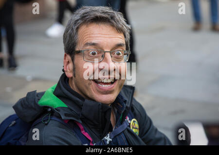 London, UK. 16 October, 2019. Guardian journalist and environmental campaigner George Monbiot sits on the pavement in Whitehall after having been arre