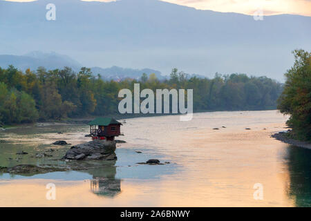 Tiny House Perched Atop a Rock in the Middle of a River. - image Stock Photo