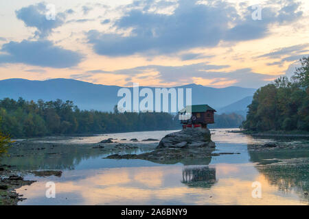 Tiny House Perched Atop a Rock in the Middle of a River. - image Stock Photo