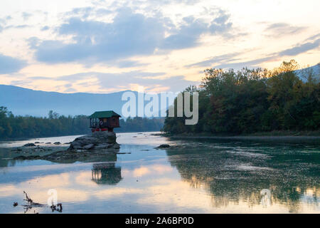 Tiny House Perched Atop a Rock in the Middle of a River. - image Stock Photo