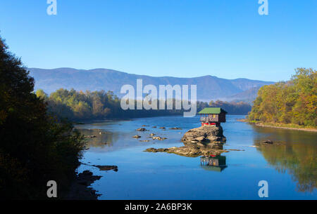 Tiny House Perched Atop a Rock in the Middle of a River. - image Stock Photo