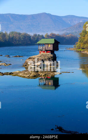 Tiny House Perched Atop a Rock in the Middle of a River. - image Stock Photo