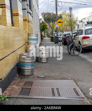 Metal beer kegs on the footpath outside a suburban hotel pub in Fitzroy Melbourne Victoria Australia. Stock Photo