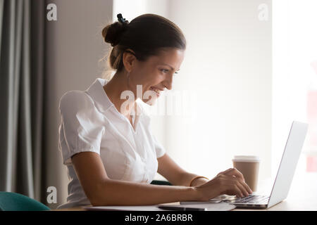 Smiling young businesswoman working on computer at office. Stock Photo