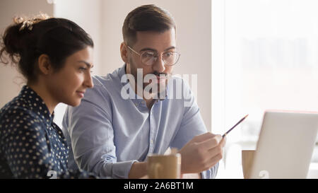 Young diverse couple of office employees working together Stock Photo