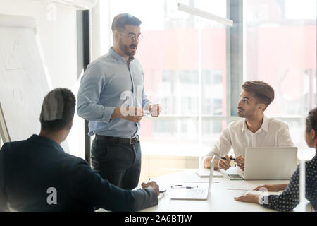 Business coach giving presentation to young team Stock Photo