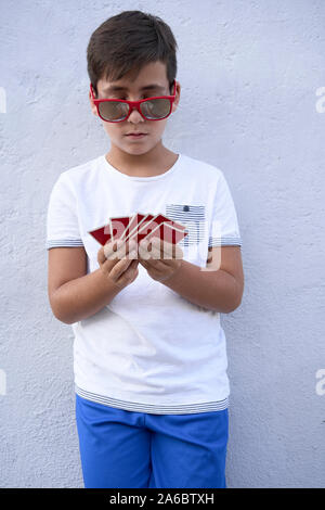 Boy with red sunglasses playing poker