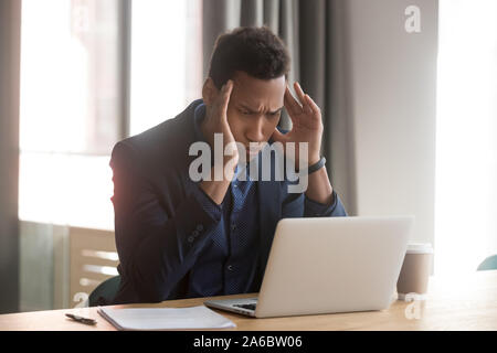 Stressed depressed african american manager feels headache at office Stock Photo