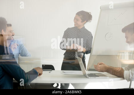 Young smiling indian woman listening to colleague Stock Photo