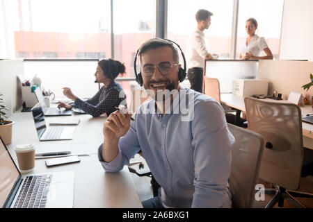 Millennial happy male call center agent looking into camera. Stock Photo