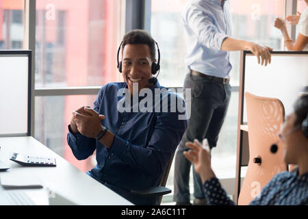 Smiling millennial black call center worker enjoying break time Stock Photo