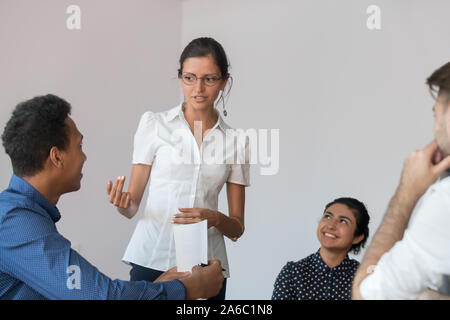 Young female team leader discussing project issues with coworkers Stock Photo