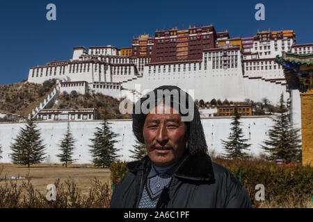A Tibetan Buddhist pilgrim from the Kham region of eastern Tibet visits Potala Palace in Lhasa, Tibet.  His hair is in traditional style with red yarn Stock Photo