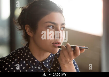 Indian woman recording audio message or using voice recognition Stock Photo