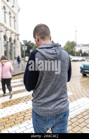 Young man using his mobile in the street Stock Photo