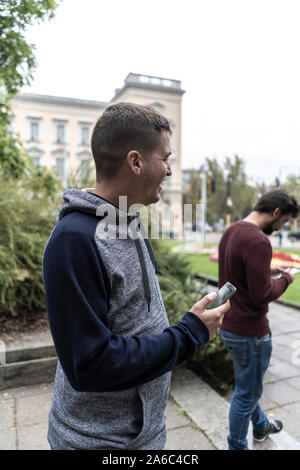 Young man using his mobile in the street Stock Photo
