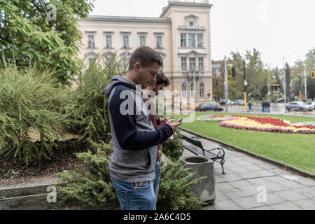 Young man using his mobile in the street Stock Photo