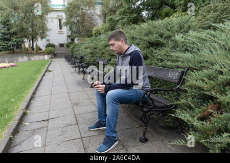 Young man using his mobile in the street Stock Photo