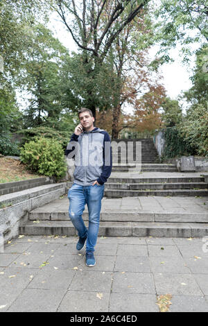 Young man using his mobile in the street Stock Photo