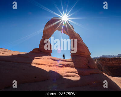 The Delicate Arch in Arches National Park, Moab, Utah, USA. Natural sandstone arch with sun above it.