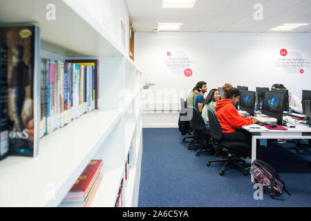 International students reading and working in the college library Stock Photo