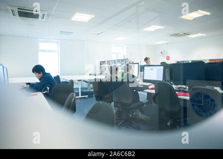 International students reading and working in the college library Stock Photo