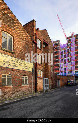 Older warehouse building in the Baltic Triangle part of Liverpool with newer buildings alongside being constructed Stock Photo