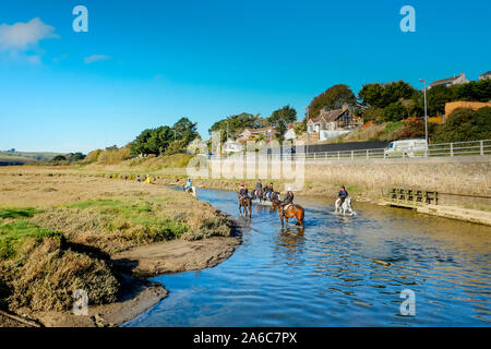 Pony trekking at low tide on the Gannel Estuary in Newquay in Cornwall. Stock Photo