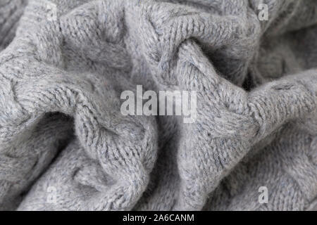 Texture of gray knitted fabric close up. Wool knitwear. Stock Photo