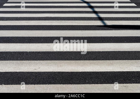 Zebra crossing, black and white stripes painted in the road. Close up. Stock Photo