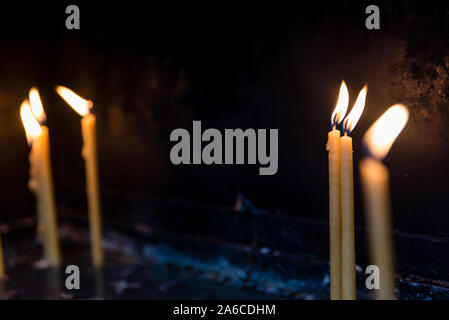 Candles at a church with only one being in focus and the rest are blurred Stock Photo