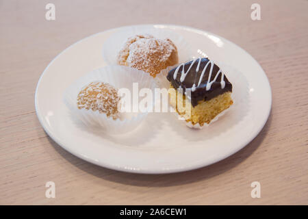 Cake inside the white plate . Slice of Three Chocolate Cake decorated with chocolate petal, on white plate, on white background. Stock Photo