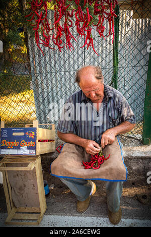 vendor making crown with fresh red chilies