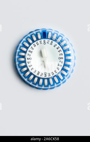 Circular pill dispenser containing hormone replacement therapy (HRT) pills. The days of the week printed on it help to remind the patient when to take the medication. HRT utilises synthetic female hormones to relieve the symptoms of either the menopause or surgical removal of the ovaries. It can also slow the loss of bone density (osteoporosis). Stock Photo