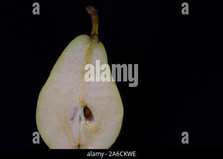 A half fresh pear lies on dark background Stock Photo