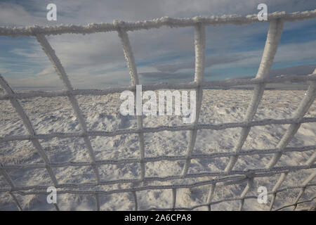 Wire fence covered in hoar frost on Whernside carpeted in snow and ice mid winter Yorkshire Dales Stock Photo