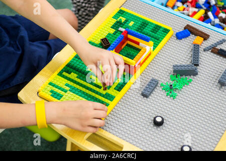 Child plays with a children's designer. The kid's plays the game designer. Stock Photo