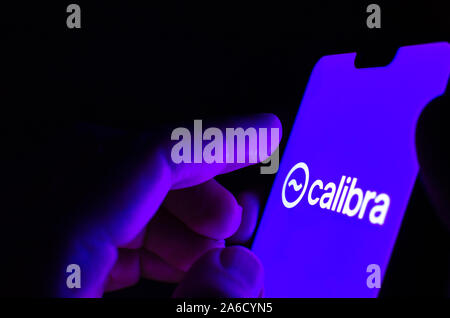 Calibra wallet logo on a smartphone screen and finger is about to touch it. Selective focus. Conceptual photo for Facebook Libra global currency. Stock Photo
